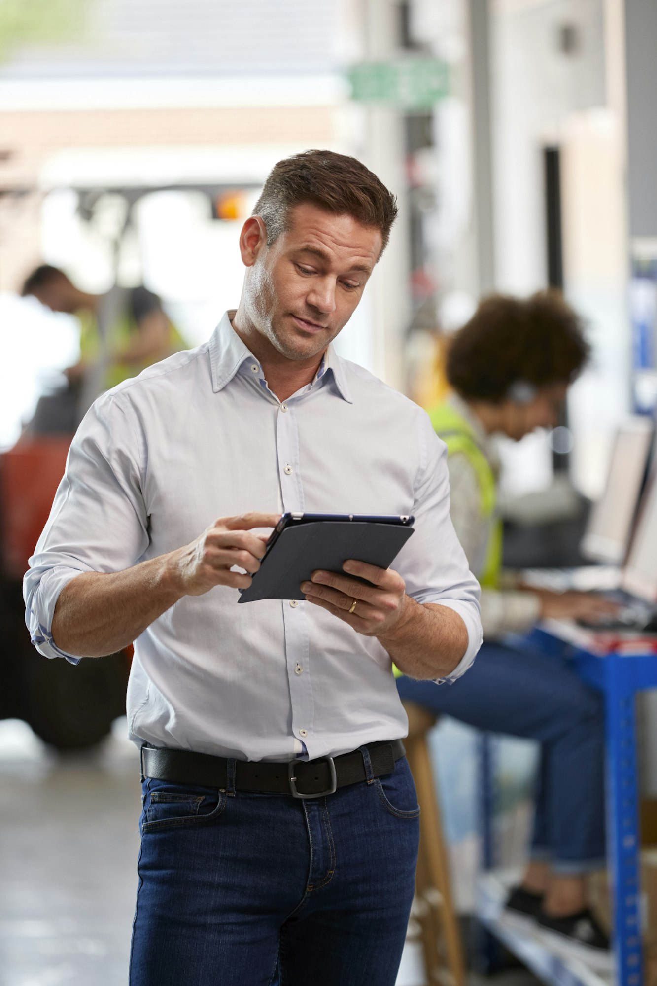 Male Manager In Logistics Distribution Warehouse Using Digital Tablet